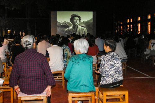 10月1日晚国际交流中心东侧露天电影放映处，晚上七点，国交东侧就坐了很多观众，观看电影《冰山上的来客》【学通社记者 吴毅博摄】